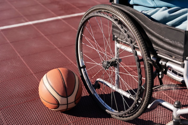 Bola de basquete de ângulo alto e cadeira de rodas