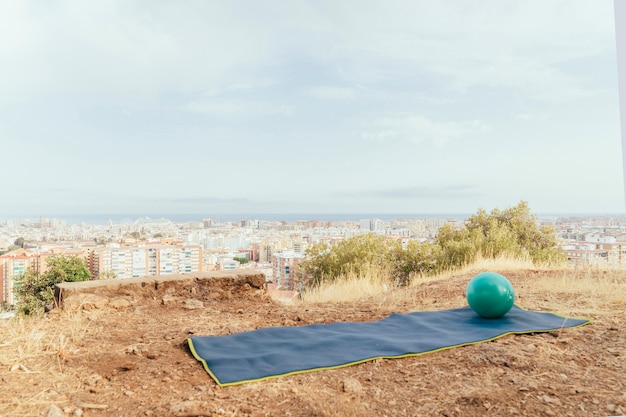 Bola e toalha para yoga com a cidade ao fundo