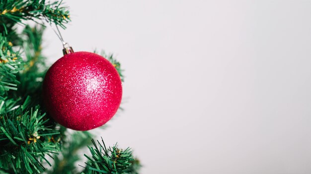 Bola vermelha na árvore de natal e espaço à direita