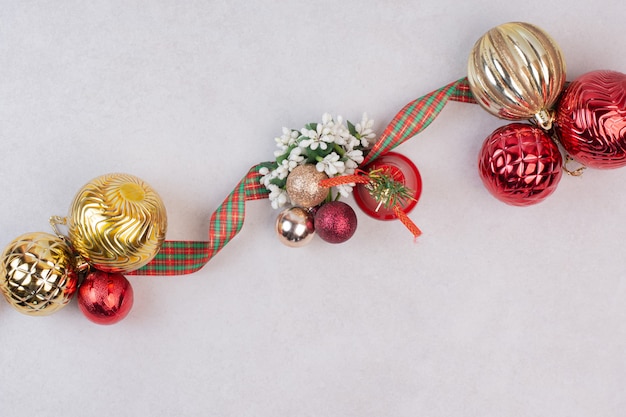 Bolas de decoração de natal com banda na superfície branca