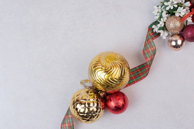 Foto grátis bolas de decoração de natal com banda na superfície branca