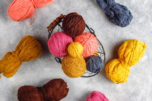 Bolas de fios em cores diferentes com agulhas de tricô.