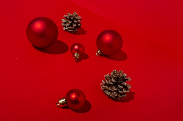 Bolas de Natal vermelhas e pinhas na mesa vermelha