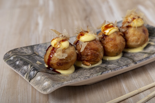 Bolas de polvo Takoyaki de comida japonesa em fundo de madeira