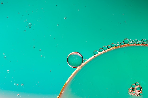 Bolhas oleosas de close-up e gotas no cenário aquoso colorido