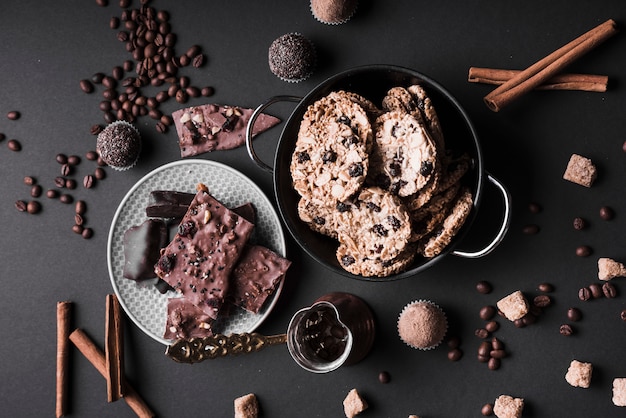 Bolinho; cookies e trufas de chocolate feitas com grãos de café e chocolate no fundo preto