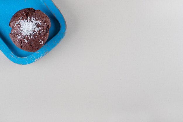 bolinho de chocolate em uma bandeja azul sobre fundo de mármore.