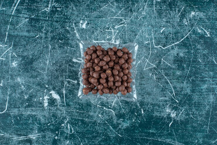 Foto grátis bolinhos de milho doce em uma tigela de vidro na superfície azul