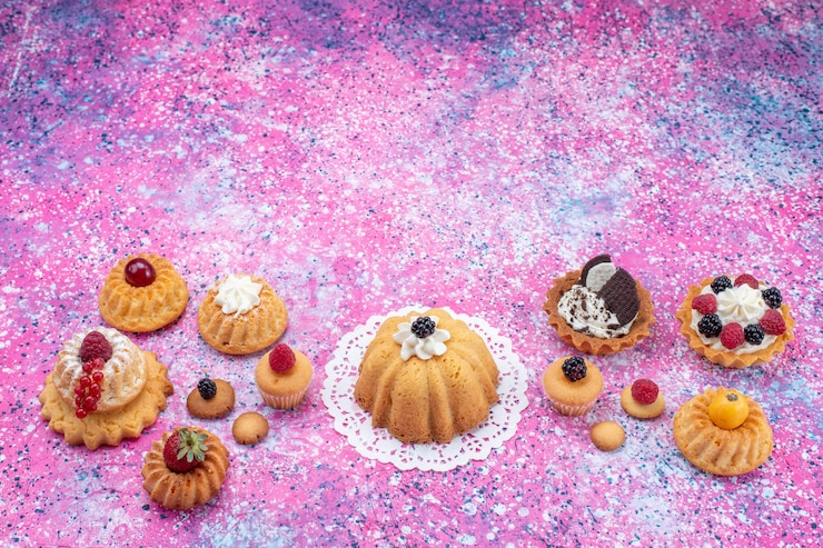 Foto grátis bolinhos deliciosos com creme e frutas vermelhas na mesa brilhante