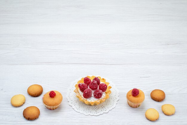 Bolinhos deliciosos com framboesas junto com biscoitos em uma mesa leve, biscoito doce de frutas vermelhas