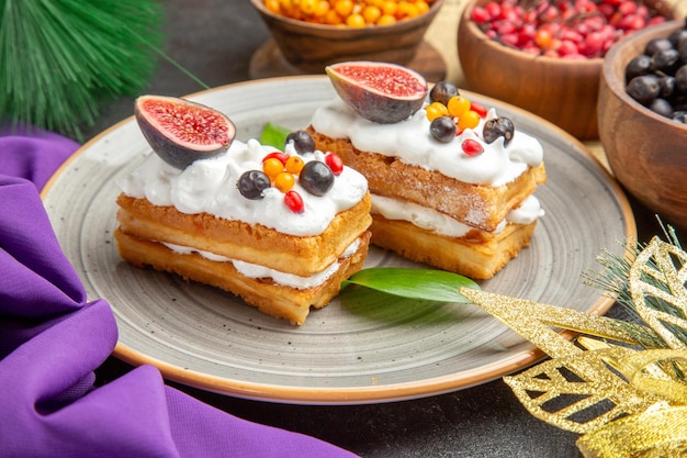 Bolinhos deliciosos de waffle com frutas frescas em fundo escuro de vista frontal