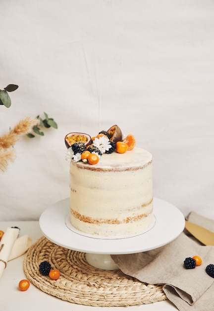 Bolo branco com frutas vermelhas e maracujá com plantas