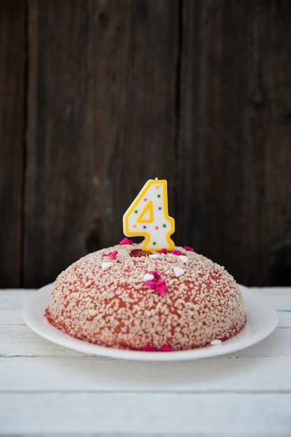 Foto grátis bolo de aniversário com quatro velas numeradas na mesa de madeira