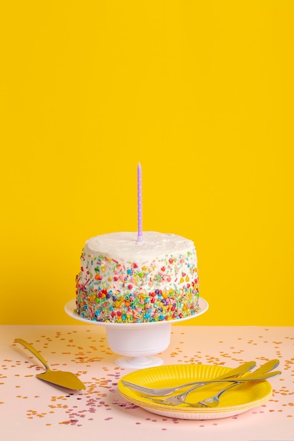 Foto grátis bolo de aniversário de ângulo alto e talheres