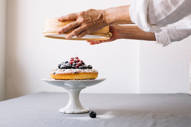 Bolo de aspersão de pessoa com pó