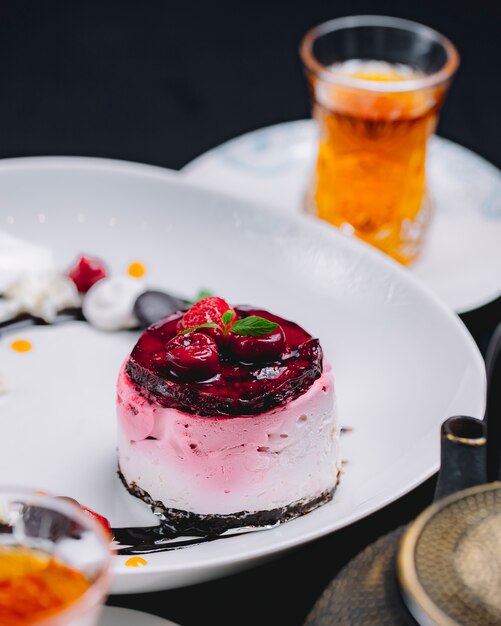 Bolo de Berry com suflê de leite cereja morango molho de chocolate chá vista lateral