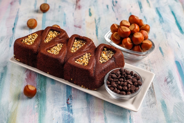 Bolo de brownie fatiado com avelãs.