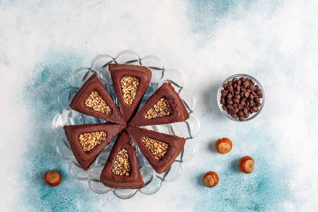 Bolo de brownie fatiado com avelãs.