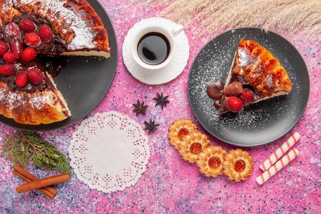 Bolo de chocolate de morango com biscoitos e chá na mesa rosa, vista de cima
