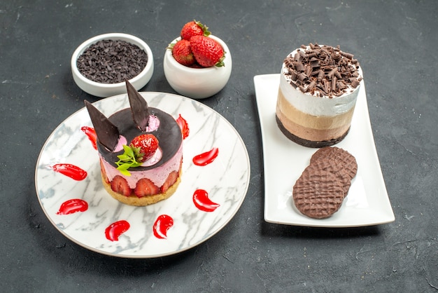 Bolo de chocolate e biscoitos em placa retangular branca cheesecake de morango em branco