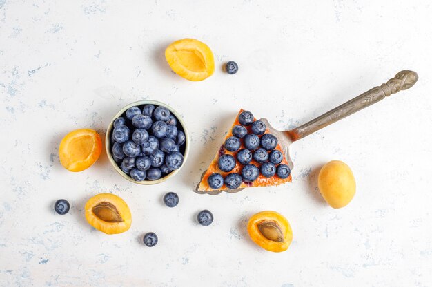 Bolo de damasco e mirtilo com mirtilos frescos e frutas de damasco.