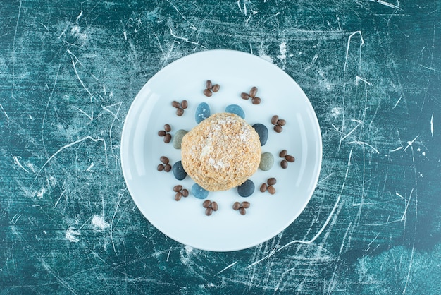 Bolo de esquilo em uma bandeja com pedras doces e grãos de café em azul.