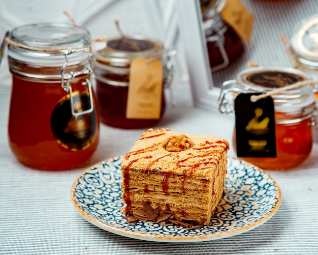 Bolo de mel quadrado com porções decorado com calda e nozes