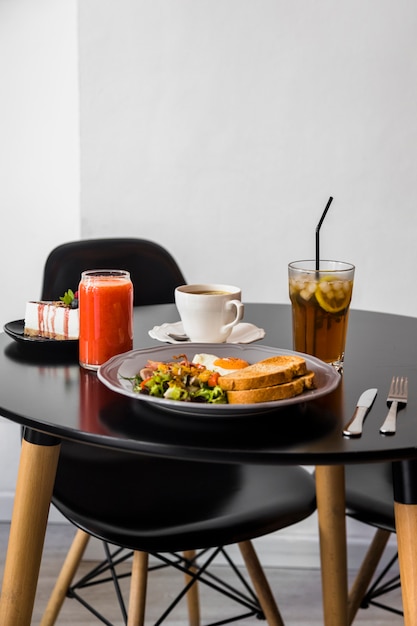 Bolo de queijo; smoothie; café; suco e café da manhã na mesa redonda preta