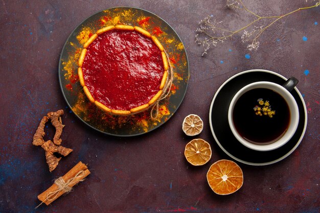 Bolo delicioso com creme vermelho e uma xícara de café no fundo escuro bolo de biscoito torta de sobremesa de açúcar bolo doce