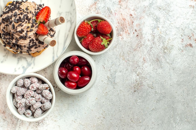 Bolo delicioso cremoso com frutas frescas na superfície branca bolo de chá de aniversário biscoito doce com vista de cima