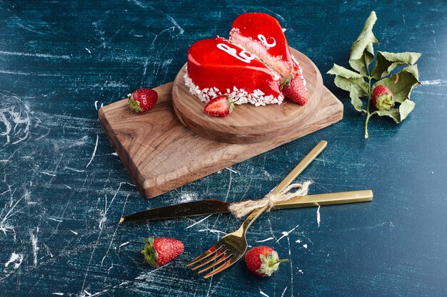 Bolo dos namorados em forma de coração com creme vermelho.