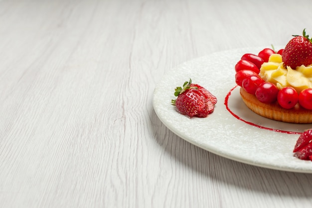 Bolo pequeno com frutas dentro do prato na mesa branca bolo de sobremesa com frutas