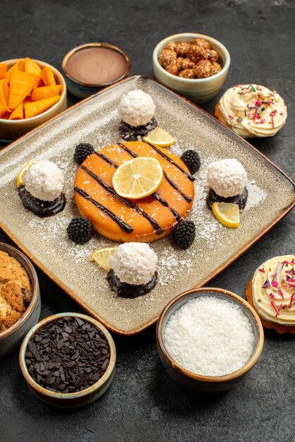 Bolo pequeno delicioso com balas de coco no fundo escuro Bolo de chá biscoito biscoito torta sobremesa