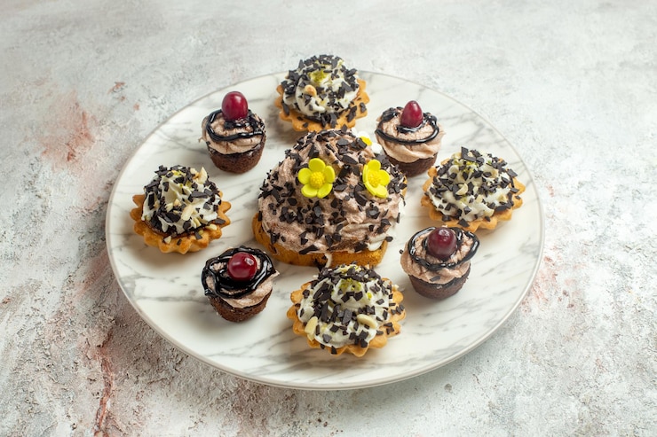 Foto grátis bolos cremosos deliciosos com casca de chocolate na superfície branca bolo biscoito biscoito chá doce creme de frente