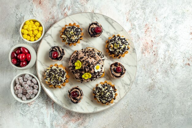 Bolos cremosos deliciosos com doces na superfície branca Bolo de chá biscoito doce creme de aniversário