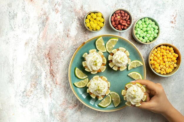 Bolos cremosos deliciosos com rodelas de limão na superfície branca bolo biscoito biscoito creme chá doce