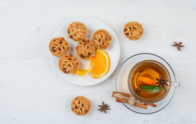 Bolos de recheio de geleia e laranja em um prato com canela e uma xícara de chá