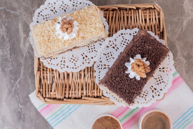 Bolos deliciosos e xícaras de café na toalha de mesa.