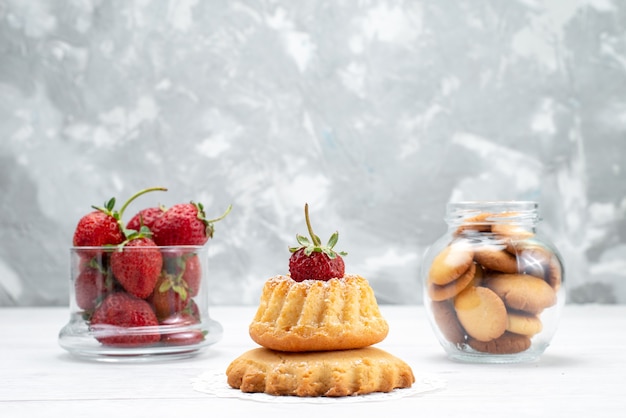 Bolozinho delicioso com morango junto com morangos e biscoitos na luz, bolo biscoito doce açúcar baga