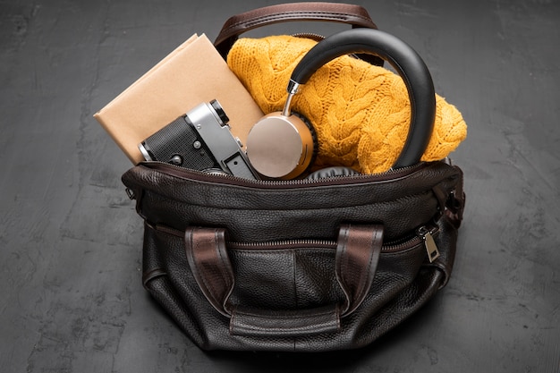 Bolsa de couro com câmera e fones de ouvido