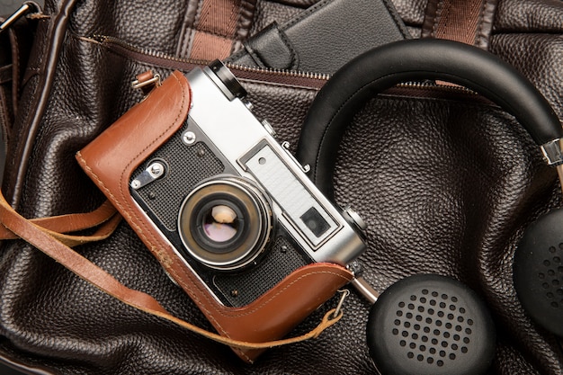Bolsa de couro para viagem com fones de ouvido e câmera