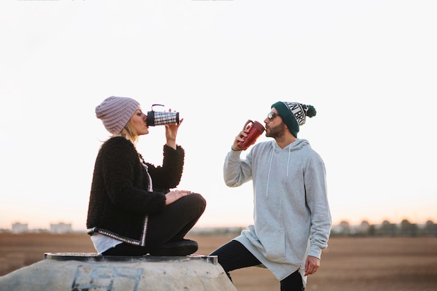 Bom casal bebendo na natureza