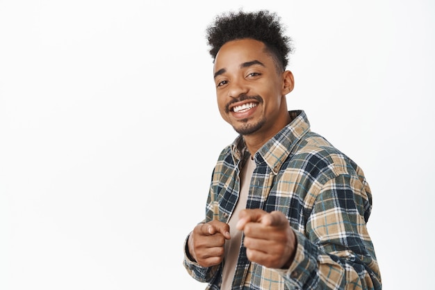 Bom trabalho, parabéns. Sorrindo bonito garoto afro-americano, cara apontando os dedos com uma cara alegre satisfeita, parabenizando você, elogie o bom trabalho em branco.