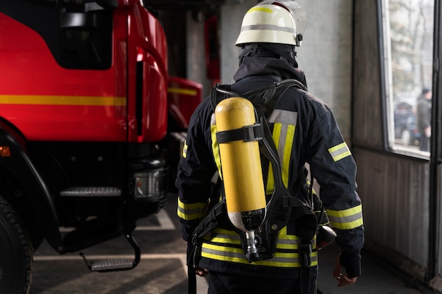 Bombeiro na estação com terno e capacete de segurança