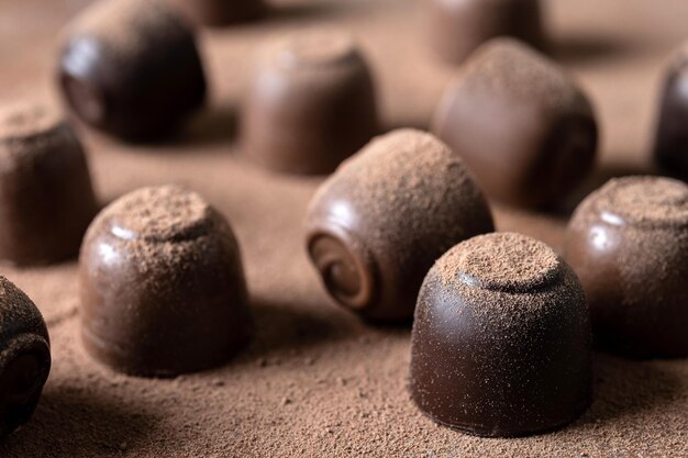 Bombons de chocolate e fundo de cacau em pó