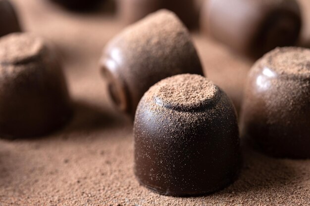 Bombons de chocolate e fundo de cacau em pó