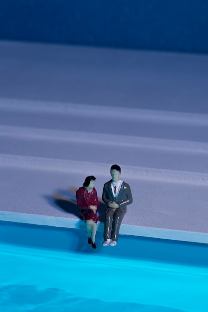 Bonecas sentadas ao lado da piscina