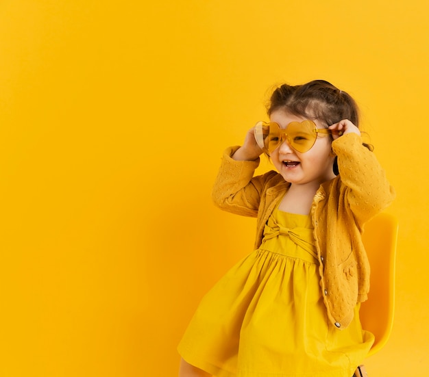 Bonita criança posando enquanto usava óculos de sol