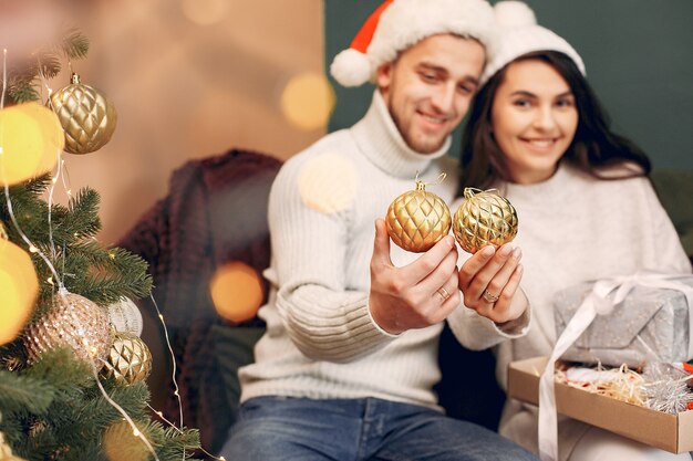 Bonita família sentada em casa perto de árvore de Natal