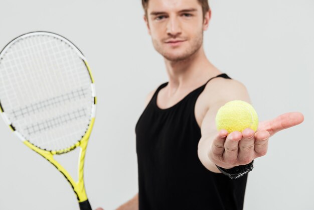 Bonita jovem desportista segurando raquete e bola de tênis